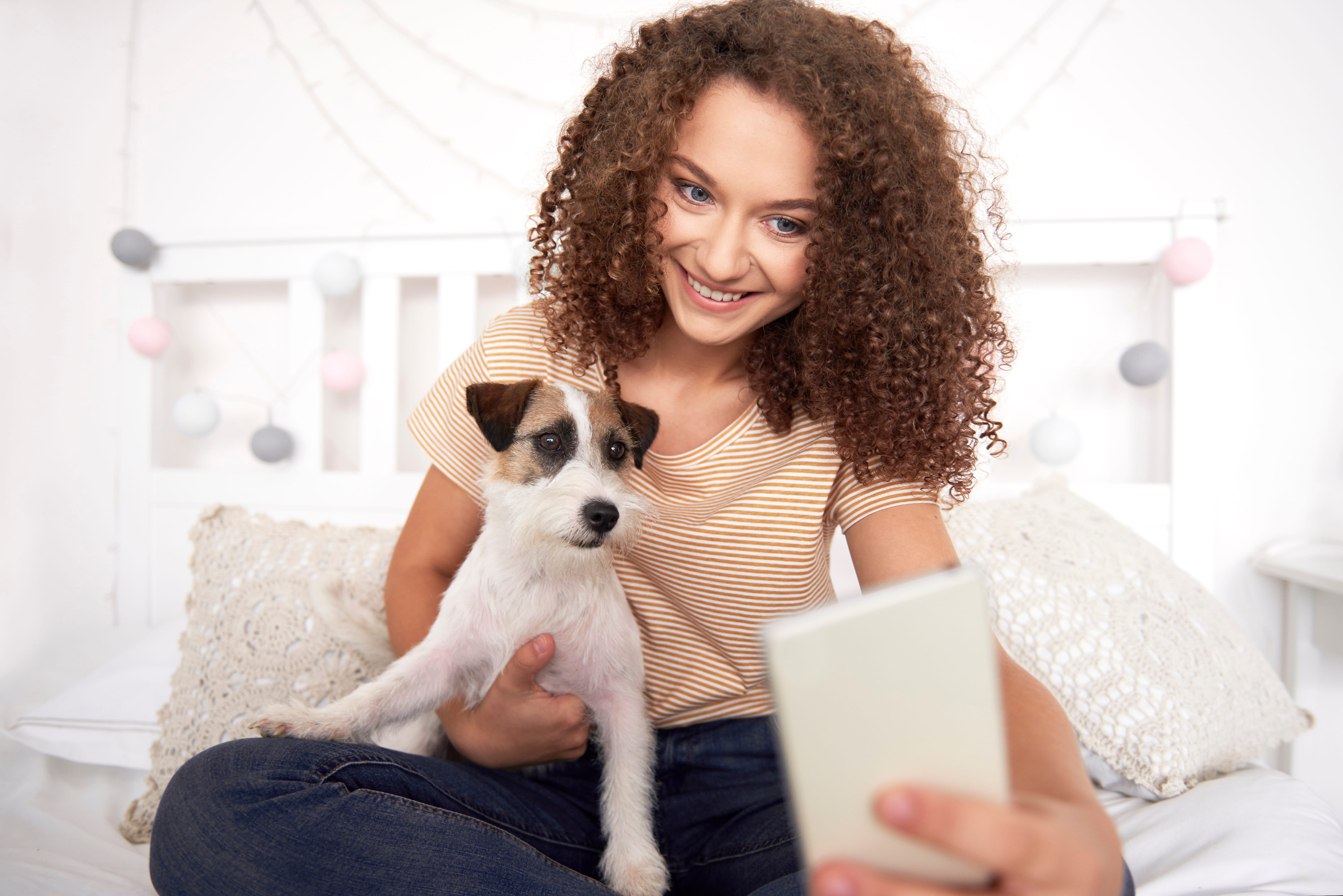 Jovem com seu cachorro usando o celular